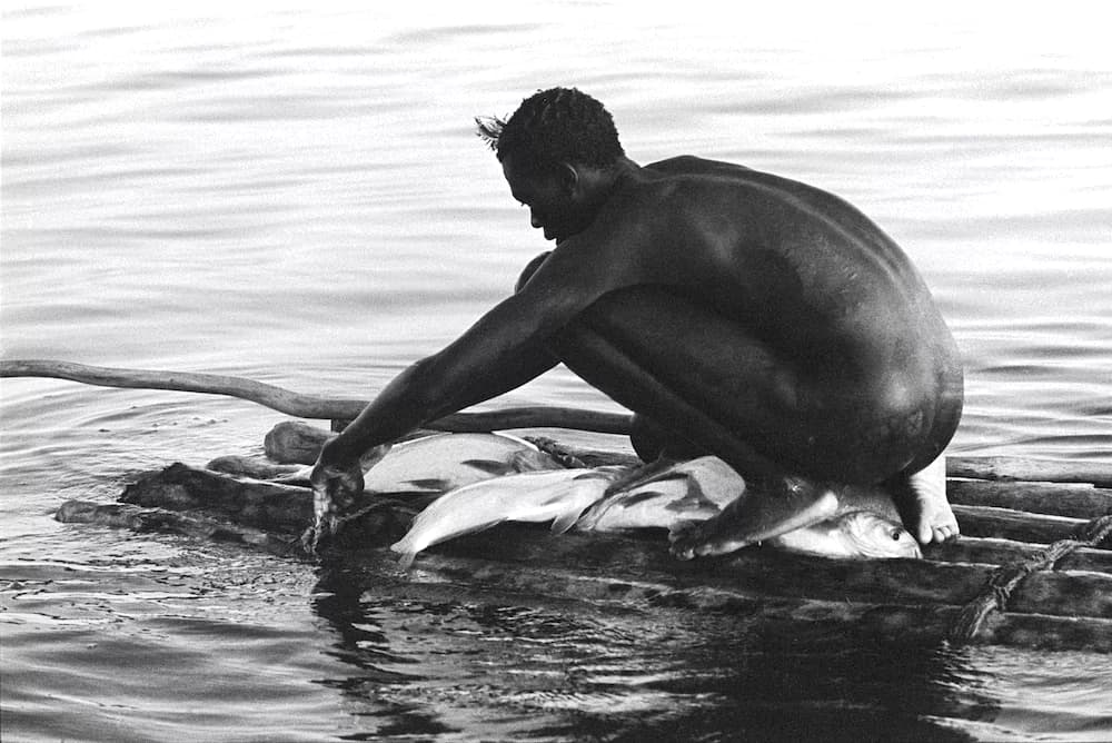 Crouching Turkana Fisherman on Raft
